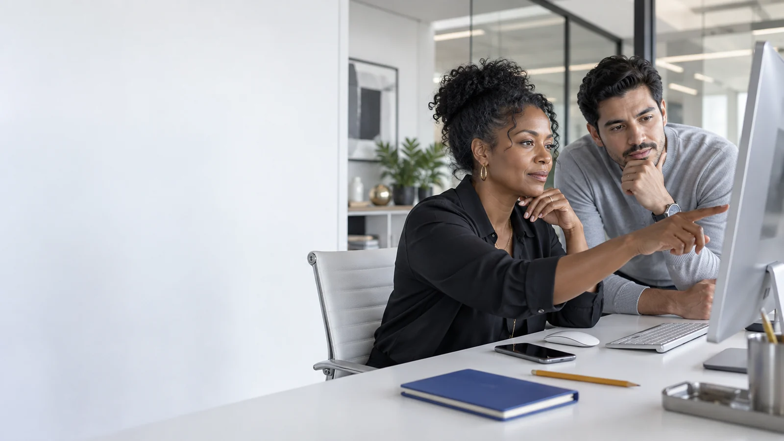 Empresaria y especialista revisando una presencia digital en una estación de trabajo.